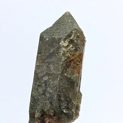 Detail of alpine quartz crystal showing smoky tone and chlorite patches from Switzerland