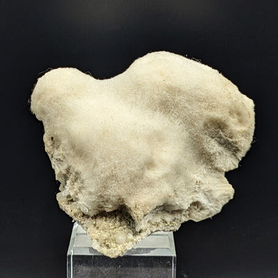 Mesolite specimen displayed on acrylic stand showing matrix base, Paterson, New Jersey