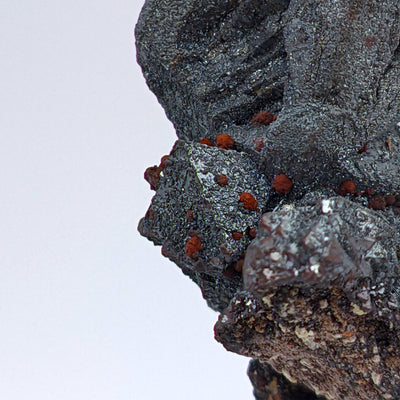 Macro view of layered octahedral hematite crystal faces with striations