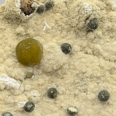 Wide view of Gyrolite sphere and scattered satellite balls on matrix, Pune, India