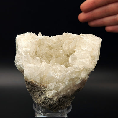 Whole colemanite crystal geode on stand shown with hand for scale, Emet, Kutahya