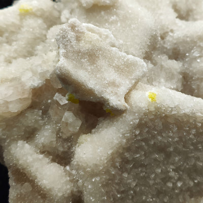 Close-up of a calcite crystal with sulfur crystals along aragonite crystal edges