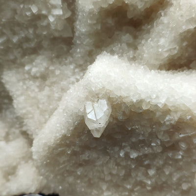 Detail of a doubly terminated clear calcite crystal on aragonite crystal surface