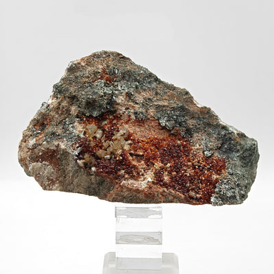 Back view of hessonite garnet specimen on matrix, mounted on acrylic stand, Bellecombe