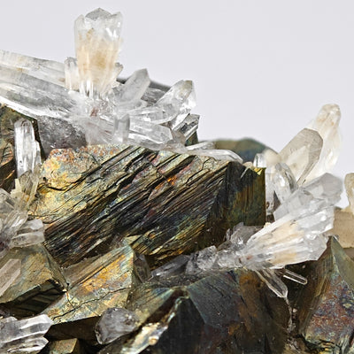 Striated arsenopyrite crystal face with quartz crystals growing around it