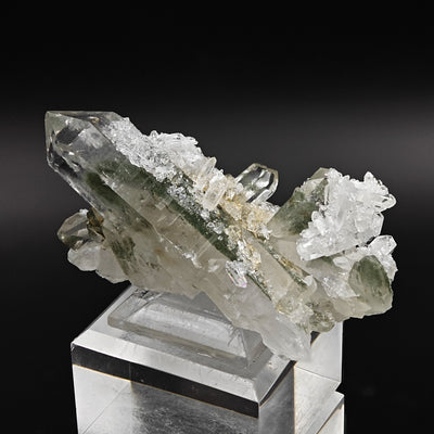 Quartz crystal cluster on acrylic stand showing multiple chlorite phantom crystals