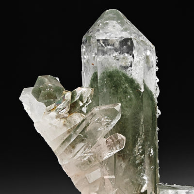 Close-up of quartz crystal group showing layered green chlorite phantoms