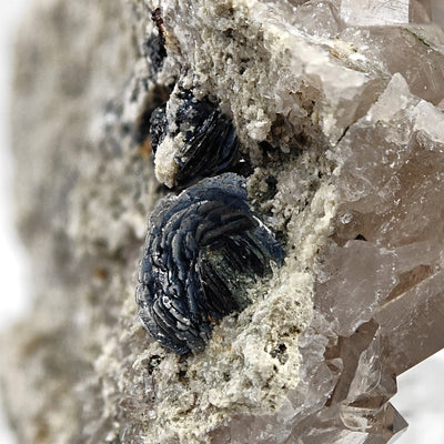 Close-up of radiating hematite rose nestled in smoky quartz matrix, Cavradi Gorge