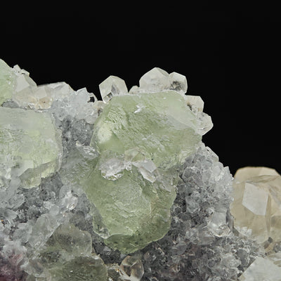 Close-up of translucent green Fluorite crystal with Calcite crystals above