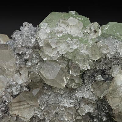Close-up of layered Calcite and green Fluorite crystals with sparkling Quartz matrix