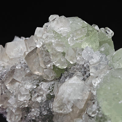 Detail of green Fluorite crystal cluster amid sharp Calcite crystals