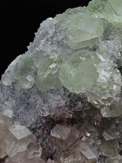 Close-up of green Fluorite crystal cluster with pale Calcite and Quartz matrix below