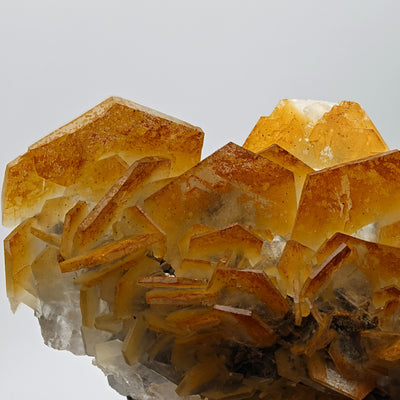 Detail of hexagonal Calcite crystal cluster showing color gradation from orange to white