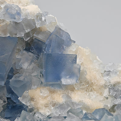 Detail of a large translucent blue fluorite cube among smaller crystals, Blanchard Mine, New Mexico