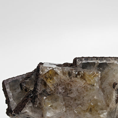 Close-up showing yellow and smoky fluorite crystal faces with brown rim