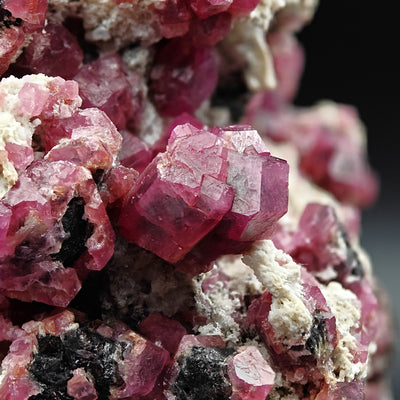 Vertical close-up of layered Rosolite Garnet crystals on matrix, Mexico