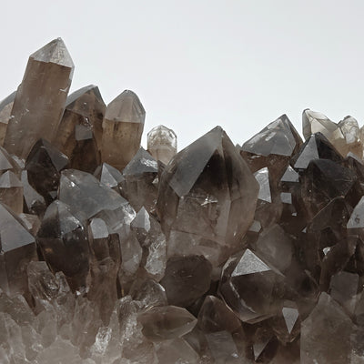 Detail of pointed smoky quartz crystal points on cluster