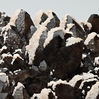Macro view of smoky quartz terminations edged with white dolomite crystals