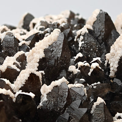 Detail of dolomite crusts lining dark smoky quartz crystal faces, Cavnic Mine