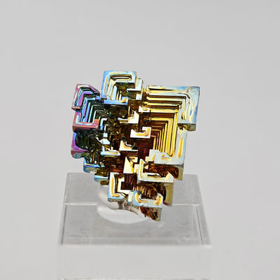 Front view of lab-grown bismuth crystal with symmetrical hopper formation and iridescent colors