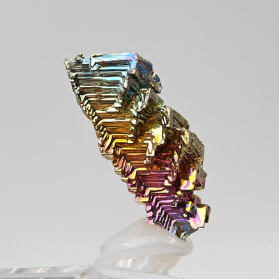 Close-up of bismuth crystal structure showing geometric stair-step growth and iridescent surface