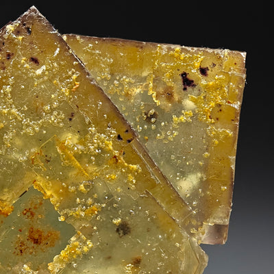 Close-up detail of fluorite crystal surface with druzy inclusions and spots