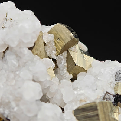 Detail of a pyrite crystal cluster nestled in calcite, Huanzala Mine, Peru