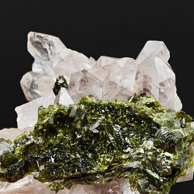 Epidote crystal spray beneath amethystine quartz crystal points