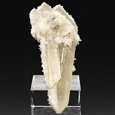 Side view of calcite-coated quartz crystal cluster on matrix