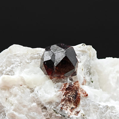 Front view of dodecahedral almandine garnet crystal on quartzite, Val Codera, Italy