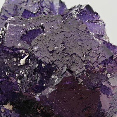 Close-up of dark purple fluorite cube showing fine growth striations