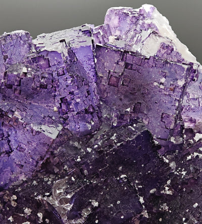 Macro view of stepped cubic fluorite faces with quartz druse accents