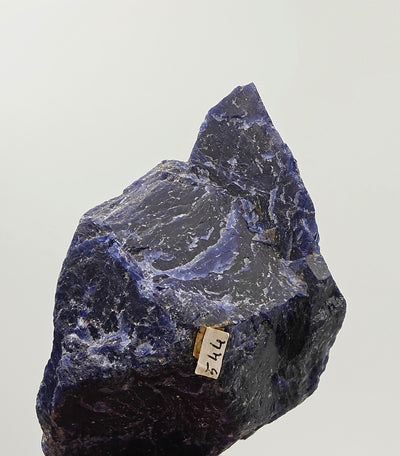 Close-up of sodalite surface with calcite veining and collection label, Namibia