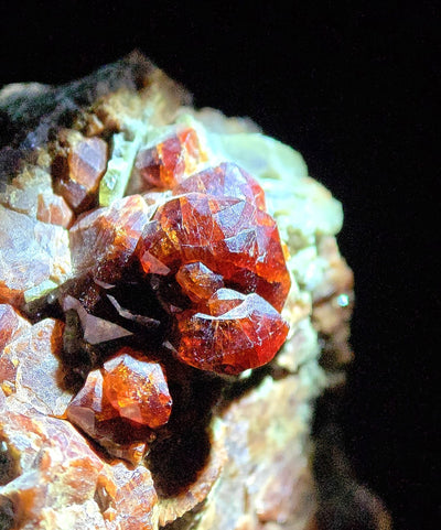 Detail of dodecahedral grossular garnet crystals with pale mica matrix