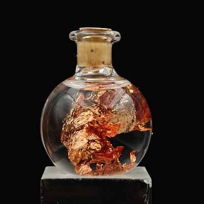 Round glass vial with native copper foil fragments, cork sealed top