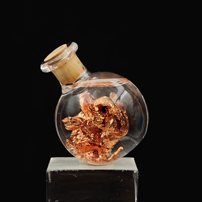Side view of glass vial showing folded native copper foil pieces