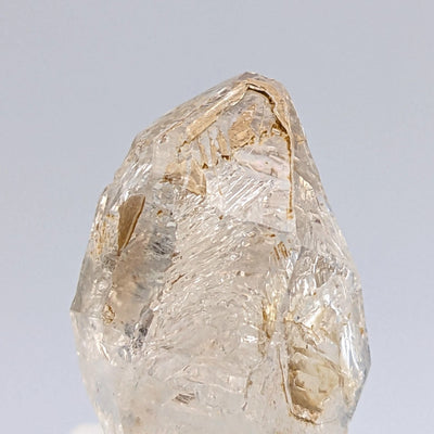 Hopper Quartz crystal termination showing golden coloration and striations