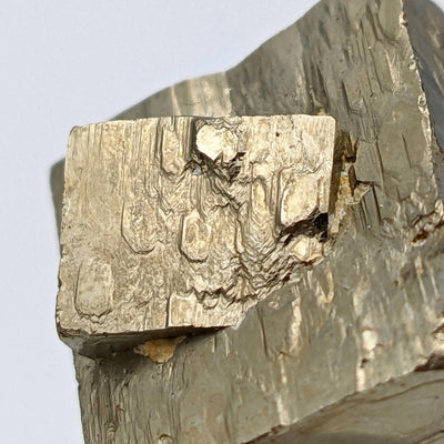 Detail of twinned pyrite crystal corner with striated faces